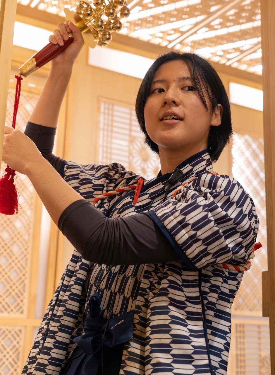 和装で神楽鈴を持つ女性スタッフ