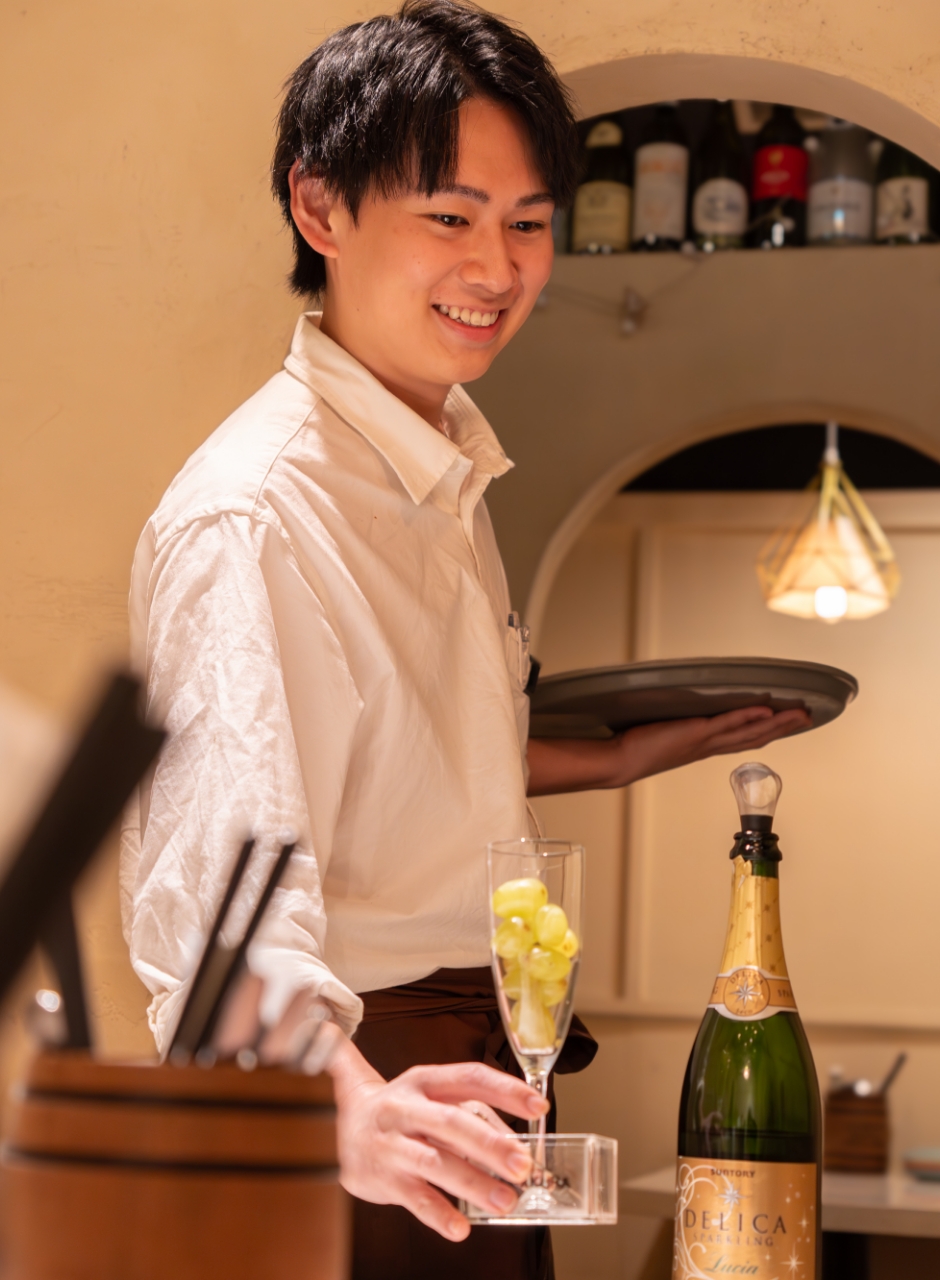 グラスを持ち接客している男性スタッフ