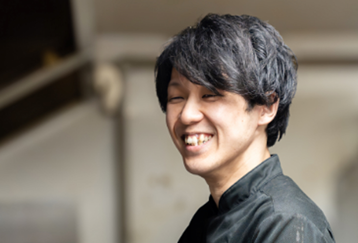 厨房で働く笑顔の男性スタッフ