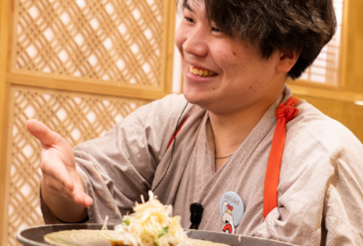 料理を提供している男性スタッフ