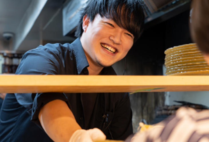 笑顔の厨房スタッフと接客スタッフ