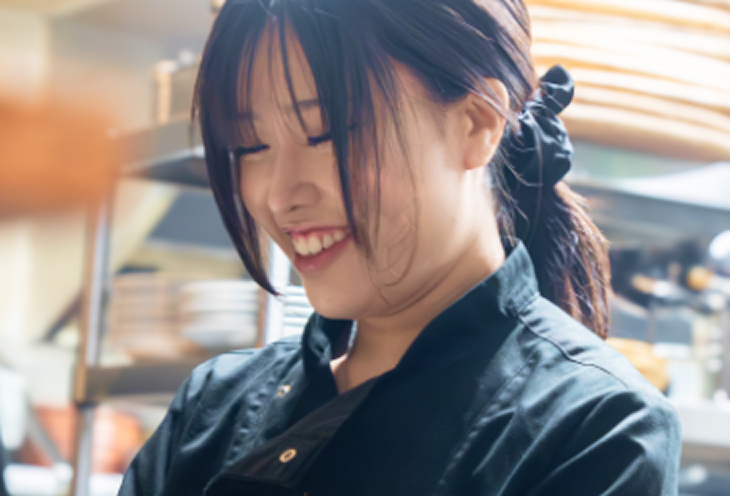 厨房で提供料理を作っている女性スタッフ