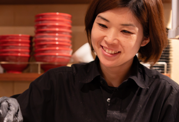 厨房で提供料理を作っている女性スタッフ