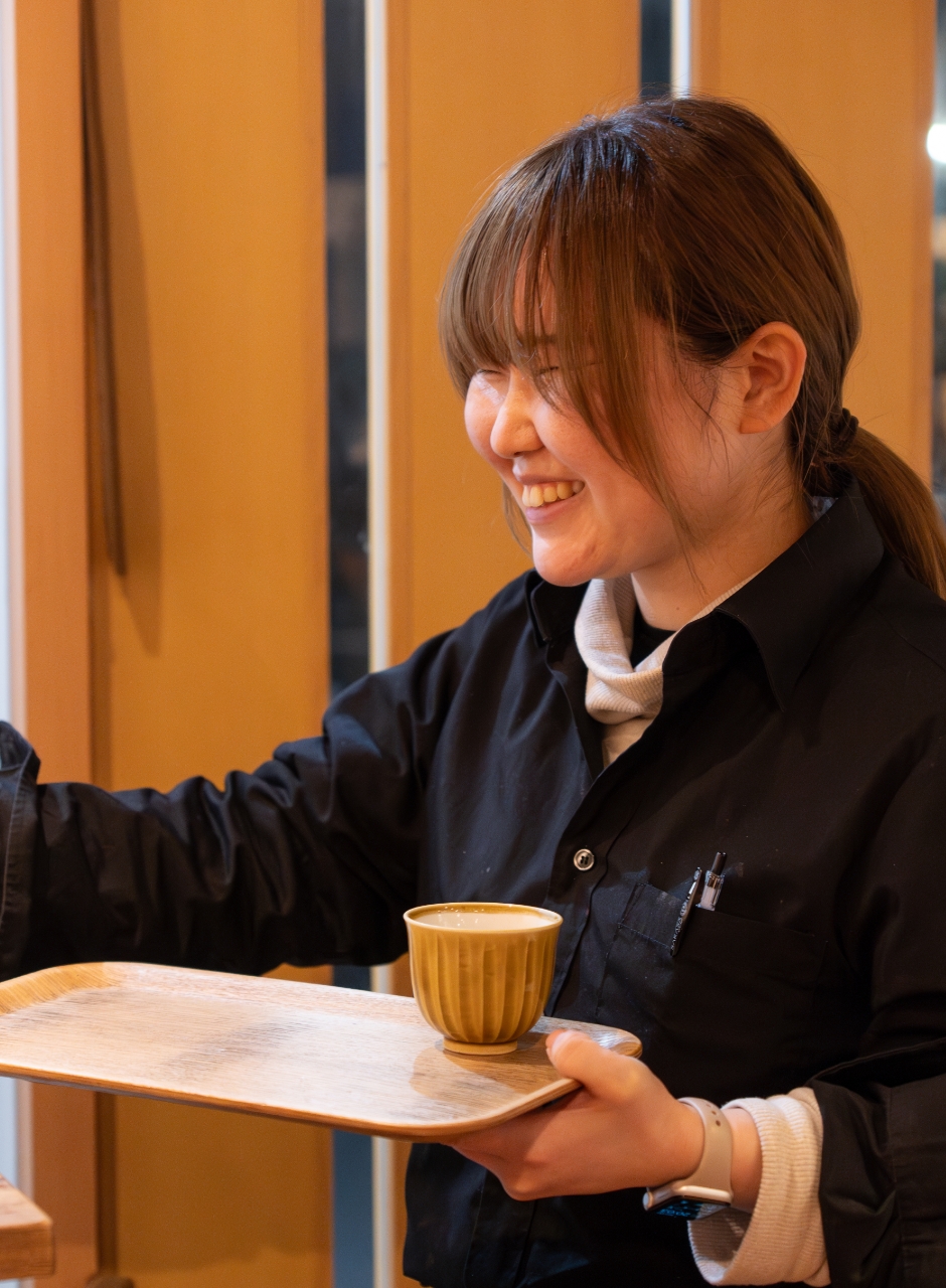 笑顔でドリンクを提供する女性スタッフ