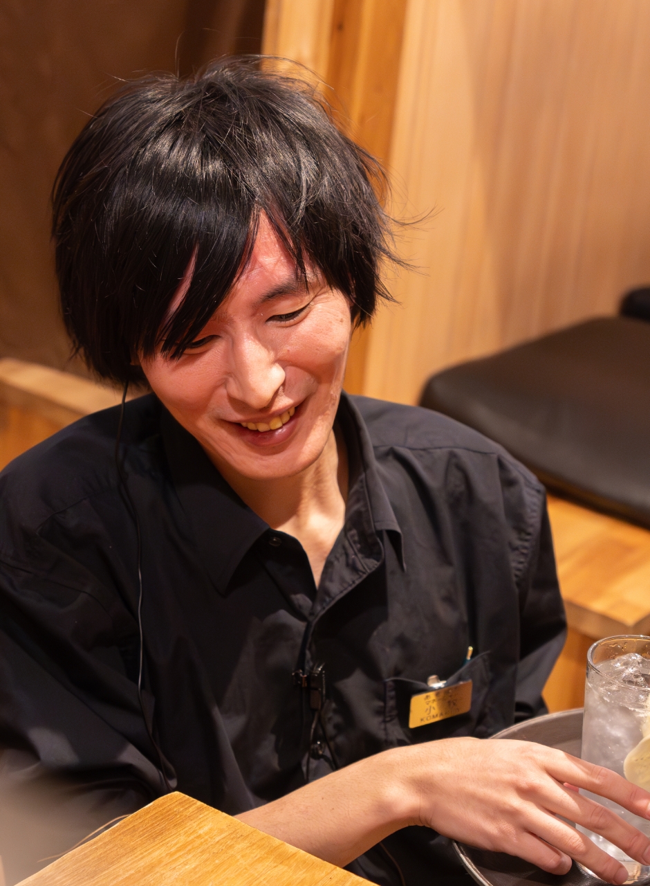 笑顔でドリンクを提供する男性スタッフ