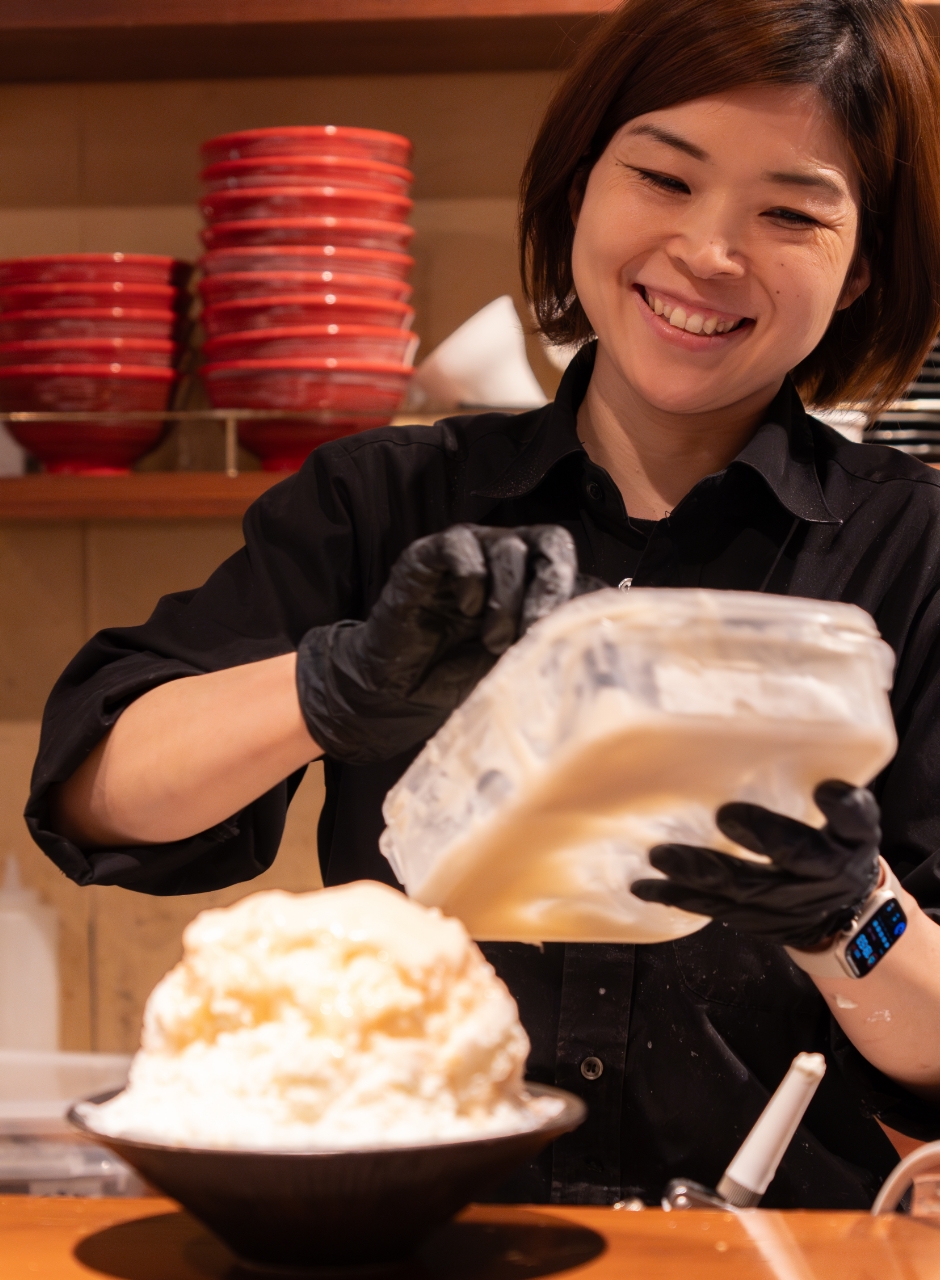 提供する料理を作る女性スタッフ