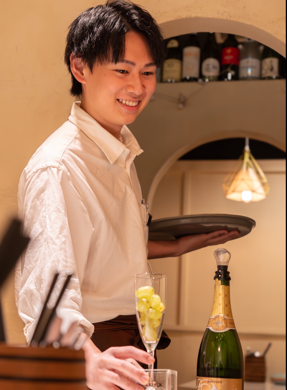 笑顔でドリンクを提供している男性スタッフ
