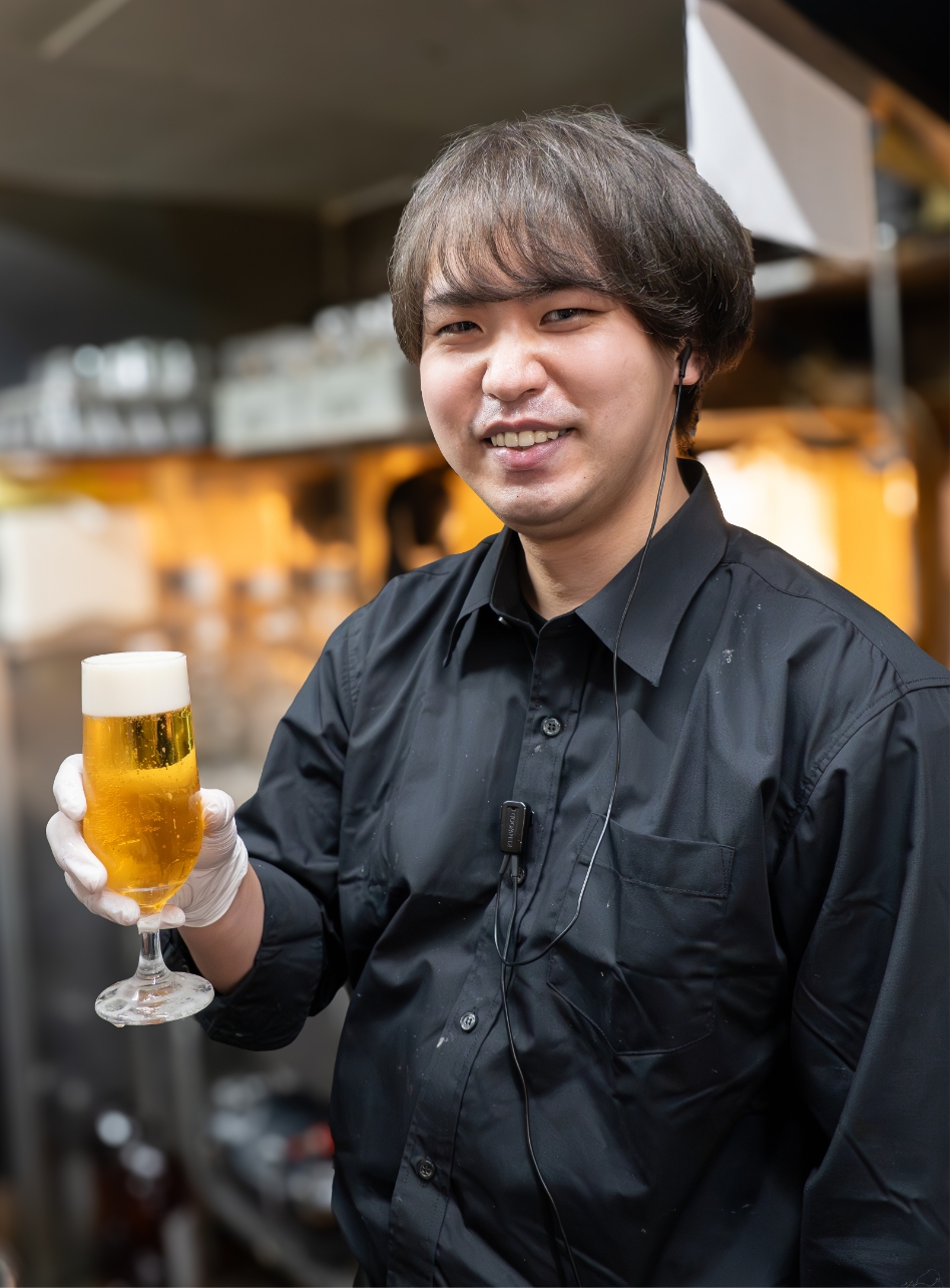 笑顔でドリンクを持っている男性スタッフ